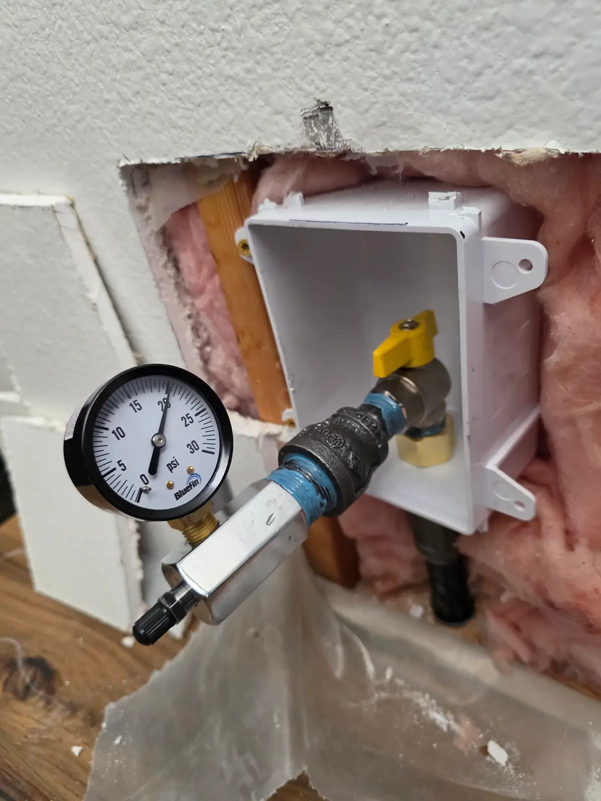 Revolution Plumbing pressure-testing a water line in an opened wall to pinpoint a hidden leak