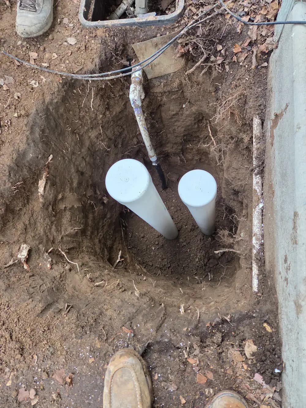 New sewer line connections set in an excavated trench during a Revolution Plumbing sewer replacement