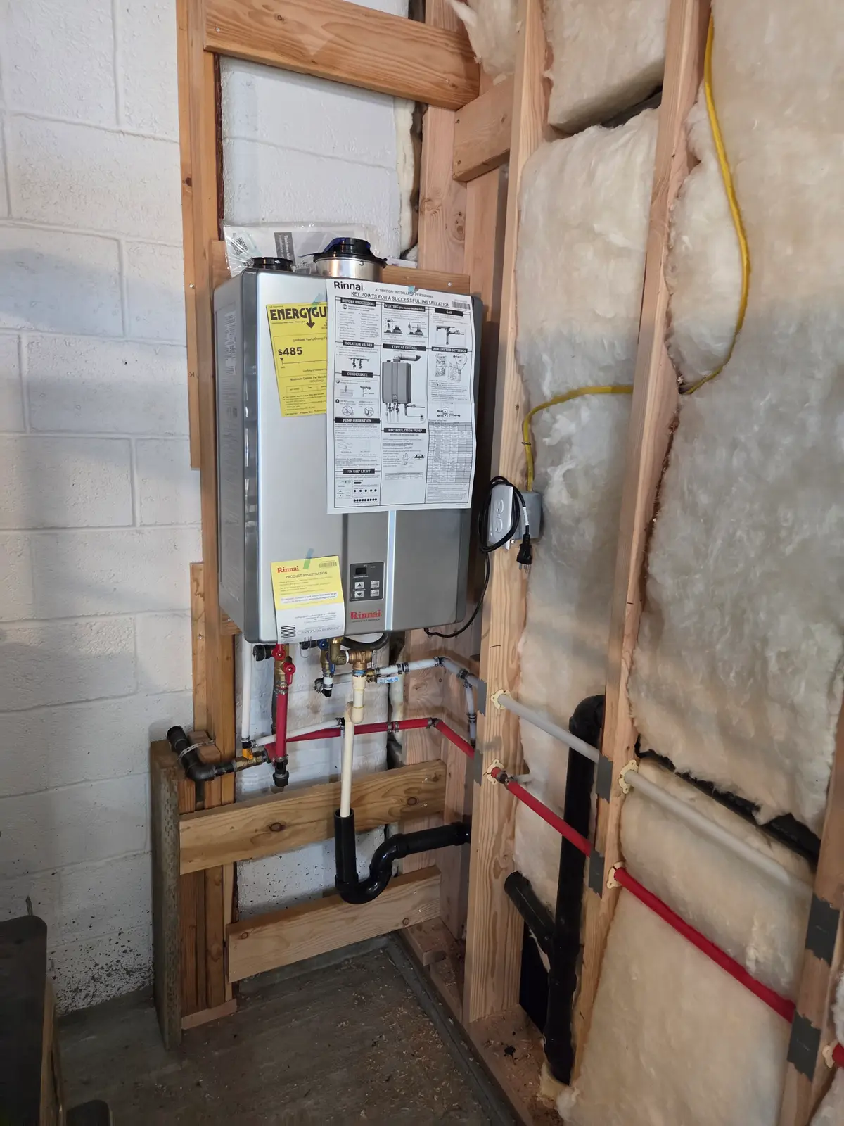 Tankless water heater installed by Revolution Plumbing with a clean PEX manifold in a Treasure Valley home